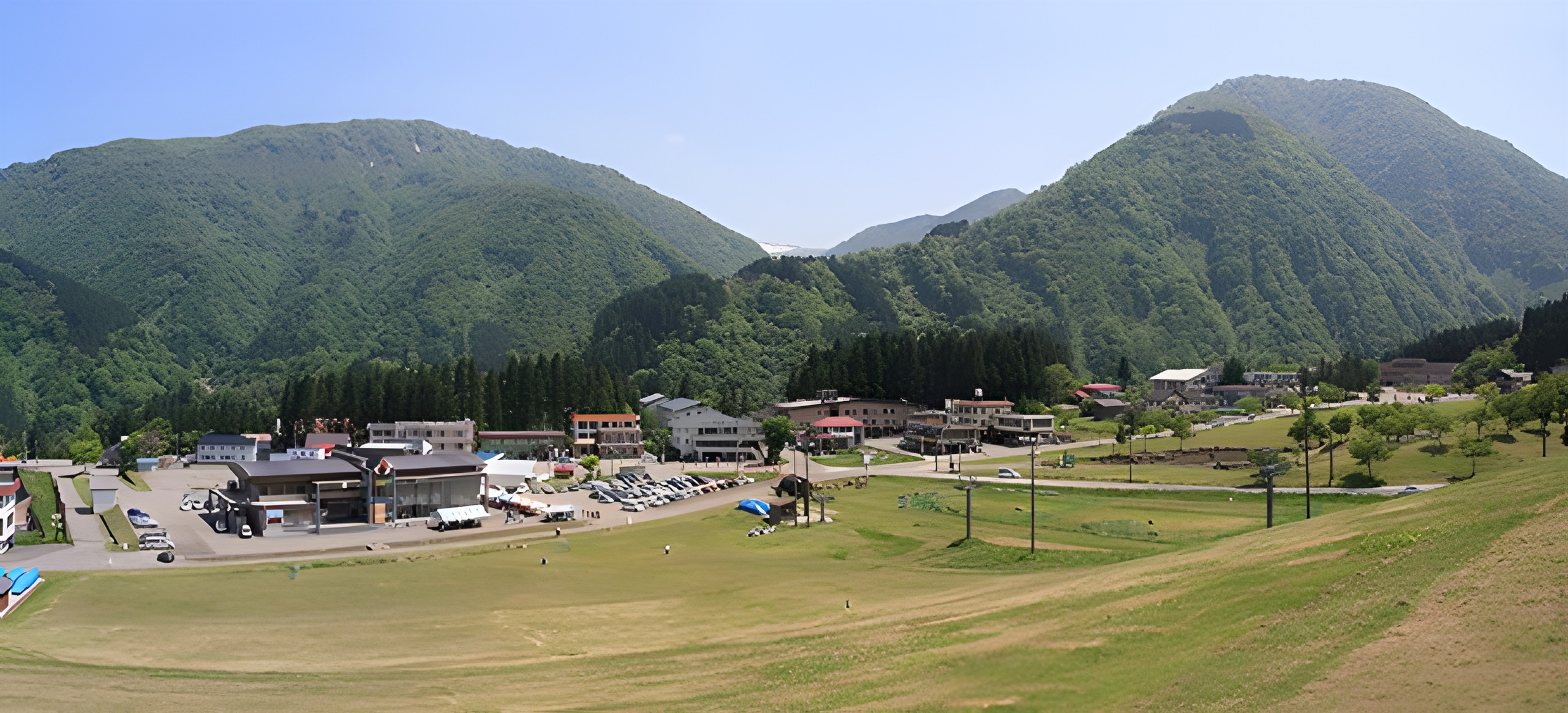 Panorama of Ichirino village and its grassy ski runs ringed by green Hakusan mountains.
